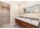 Bathroom featuring double sink vanity, stone tile backsplash and glass enclosed shower at 4353 Indian Point Trl, Sarasota, FL 34238