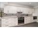 Well-appointed kitchen featuring stainless steel appliances, white cabinetry, and modern backsplash at 4353 Indian Point Trl, Sarasota, FL 34238