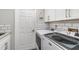 Bright laundry room featuring subway tile backsplash, a white door, and front loading washer and dryer at 4353 Indian Point Trl, Sarasota, FL 34238
