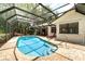 Backyard oasis featuring a screened-in pool and brick patio with lounge chairs and meticulously maintained landscaping at 4353 Indian Point Trl, Sarasota, FL 34238