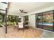 Screened-in patio with brick flooring, ceiling fan, outdoor furniture, and sliding glass doors at 4353 Indian Point Trl, Sarasota, FL 34238