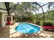 Enclosed in a screen, the backyard oasis offers a private pool and brick patio with lounge chairs at 4353 Indian Point Trl, Sarasota, FL 34238