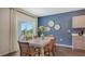 Dining area with a white table, wicker chairs, slider doors to the backyard, and designer wall decor at 4425 Boxelder Avenue, Parrish, FL 34219