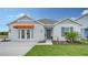 Charming single-story home with an orange awning, blue door, and freshly manicured lawn at 4425 Boxelder Avenue, Parrish, FL 34219