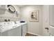 Practical laundry room equipped with a washer and dryer, wire shelving, and a wall art print at 4425 Boxelder Avenue, Parrish, FL 34219