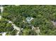 Aerial view of a luxury property nestled in a dense tree canopy with a sparkling private pool at 4511 Windsor Park, Sarasota, FL 34235