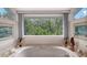 A sun-drenched bathtub view showcasing a picturesque view of the lush greenery outside the window at 4511 Windsor Park, Sarasota, FL 34235