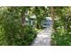 Well-maintained home with lush landscaping and a concrete driveway, nestled in a serene, wooded setting at 4511 Windsor Park, Sarasota, FL 34235