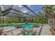 Sparkling screened-in pool surrounded by lush landscaping and comfortable seating area at 4511 Windsor Park, Sarasota, FL 34235