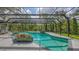 A large screened pool with a lush green view surrounded by an aluminum screen and featuring tiled planters at 4511 Windsor Park, Sarasota, FL 34235