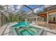 Backyard view of the screened-in pool and spa area, complete with a covered lanai and lush landscaping at 4511 Windsor Park, Sarasota, FL 34235