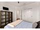 This bedroom has a TV, a storage unit and a large bed with a decorative throw blanket at 4617 Garden Arbor Way, Bradenton, FL 34203