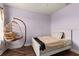 This bedroom has hardwood floors, light purple walls and a hanging chair in the corner at 4617 Garden Arbor Way, Bradenton, FL 34203