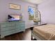 Light purple bedroom featuring hardwood floors, blue dresser, mounted TV and a hanging chair at 4617 Garden Arbor Way, Bradenton, FL 34203