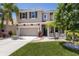 Charming two-story home featuring a well-manicured lawn, palm trees, and a two-car garage at 4617 Garden Arbor Way, Bradenton, FL 34203