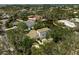Aerial view of a luxurious two-story home nestled amongst lush tropical foliage, with a waterfront view at 4831 Primrose Path, Sarasota, FL 34242