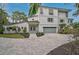 Elegant two-story home with a paved driveway, well-manicured landscaping, and a modern architectural design at 4831 Primrose Path, Sarasota, FL 34242