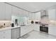 Well-lit kitchen with stainless steel appliances, white cabinets, and modern fixtures at 4831 Primrose Path, Sarasota, FL 34242