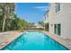 Inviting backyard pool with brick pavers, with the house and palm trees surrounding it at 4831 Primrose Path, Sarasota, FL 34242