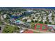 Aerial view of a community featuring a pond, pool, tennis court and neatly arranged homes at 4832 Independence Dr, Bradenton, FL 34210