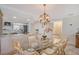 Charming dining area with a glass table and comfortable seating, lit by an elegant chandelier, next to the kitchen at 4832 Independence Dr, Bradenton, FL 34210