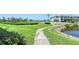 Beautifully maintained grounds with landscaped lawn, walkway, mature trees, and pond view at 4832 Independence Dr, Bradenton, FL 34210