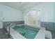 Bright indoor pool with easy access steps, handrail and decorative glass block window at 4832 Independence Dr, Bradenton, FL 34210