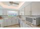 Modern kitchen featuring white cabinets, stainless steel appliances, and a sleek backsplash, for an attractive cooking area at 4832 Independence Dr, Bradenton, FL 34210