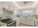 Updated kitchen featuring sleek white cabinets, stainless steel appliances, and a modern backsplash, providing a clean cooking space at 4832 Independence Dr, Bradenton, FL 34210