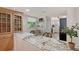 Bright kitchen area featuring a breakfast bar with stunning countertops, complemented by decorative glass cabinets and modern appliances at 4832 Independence Dr, Bradenton, FL 34210