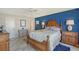 Spacious main bedroom with a blue accent wall, tile floor, and comfortable furniture at 4832 Independence Dr, Bradenton, FL 34210