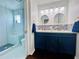 Elegant bathroom with double sinks, blue vanity, and a glass-enclosed shower at 4907 Kilty E Ct, Bradenton, FL 34203