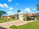 Attractive single-story home featuring lush landscaping, a brick driveway, and a two-car garage under a sunny blue sky at 4907 Kilty E Ct, Bradenton, FL 34203