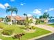 Beautiful single-story home with well-manicured lawn, lush landscaping and a brick driveway under a sunny blue sky at 4907 Kilty E Ct, Bradenton, FL 34203