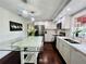 Bright white kitchen with modern stainless steel appliances, a glass island, and stylish light fixtures for dining at 4907 Kilty E Ct, Bradenton, FL 34203