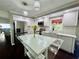 Bright white kitchen with modern stainless steel appliances, a glass island, and stylish light fixtures at 4907 Kilty E Ct, Bradenton, FL 34203