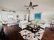 Bright living room showcasing hardwood floors, stylish sofas, a ceiling fan, and an adjacent dining area at 4907 Kilty E Ct, Bradenton, FL 34203