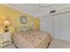 Inviting bedroom with a ceiling fan, bedside tables with lamps, and ample closet space at 519 Albee Farm Rd # 212, Venice, FL 34285