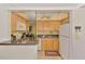 Functional kitchen with light wood cabinets, granite countertops, and a white refrigerator at 519 Albee Farm Rd # 212, Venice, FL 34285