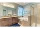Elegant bathroom features double sinks, a large soaking tub, and a glass enclosed shower at 5307 65Th E Ter, Ellenton, FL 34222