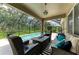 Inviting screened porch with comfortable wicker furniture, striped rug, and fire pit near the pool at 5307 65Th E Ter, Ellenton, FL 34222