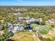 Aerial view of golf course, club house, and surrounding neighborhood and mature trees at 5349 Everwood Run, Sarasota, FL 34235