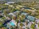 An aerial view featuring a community swimming pool and tennis courts set amidst a green landscape and parking area at 5349 Everwood Run, Sarasota, FL 34235