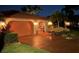Charming home exterior with a tile roof, arched entryways, and lush landscaping in a well-lit setting at 5349 Everwood Run, Sarasota, FL 34235