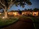 Picturesque home exterior with a circular driveway, lush landscaping, and warm lighting for an inviting curb appeal at 5349 Everwood Run, Sarasota, FL 34235