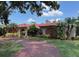 Charming one-story home with a red tile roof, arched entryway and meticulously landscaped front yard at 5349 Everwood Run, Sarasota, FL 34235