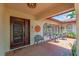 Cozy front porch with decorative iron door, seating, tiled flooring, and charming decorative accents at 5349 Everwood Run, Sarasota, FL 34235