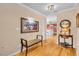 Inviting hallway with hardwood floors, neutral walls, decorative artwork and table with lamp at 5349 Everwood Run, Sarasota, FL 34235