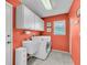 Functional laundry room with washer, dryer, utility sink, storage cabinets, and tiled floor at 5349 Everwood Run, Sarasota, FL 34235