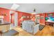 Cozy living room with bright orange walls, white couches, and beach-themed decor offers a welcoming atmosphere at 5349 Everwood Run, Sarasota, FL 34235